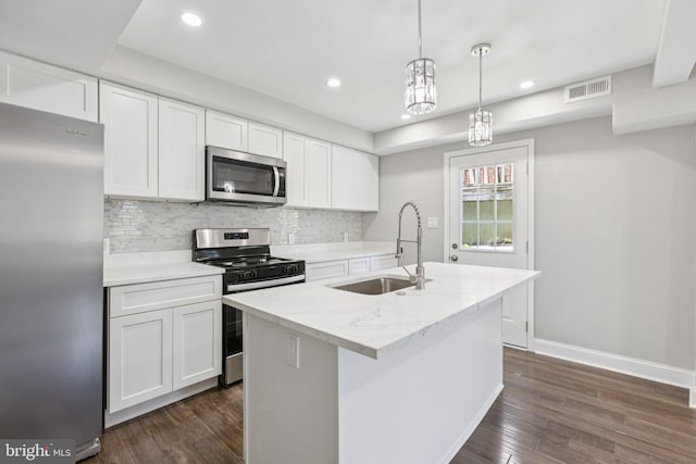 844 51st St NE, Washington, DC 20019 - kitchen featuring stainless steel appliances, a sink, dark wood finished floors, white cabinets, and tasteful backsplash