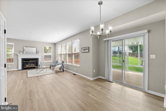 21788 Regents Park Cir, Sterling, VA 20166 - unfurnished living room with baseboards, light wood-style flooring, and a chandelier