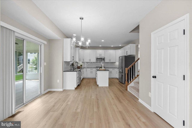 21788 Regents Park Cir, Sterling, VA 20166 - kitchen with appliances with stainless steel finishes, backsplash, light wood-style floors, a chandelier, and recessed lighting