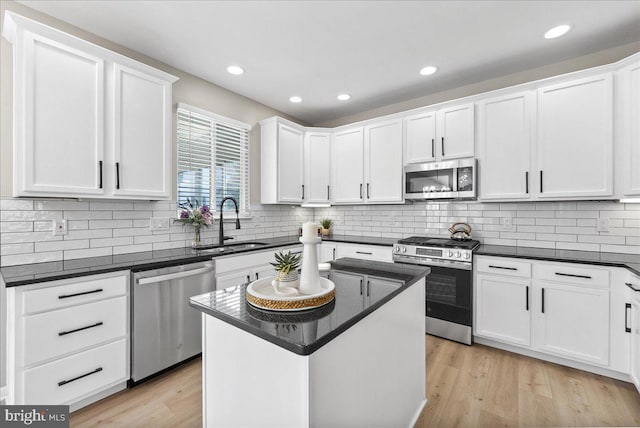 21788 Regents Park Cir, Sterling, VA 20166 - kitchen featuring stainless steel appliances, a sink, white cabinets, light wood finished floors, and backsplash
