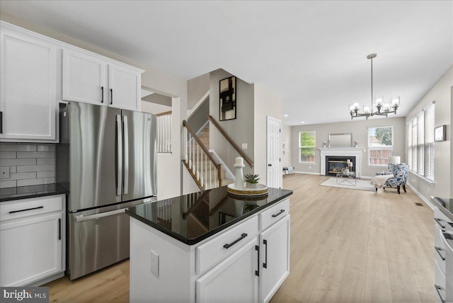 21788 Regents Park Cir, Sterling, VA 20166 - kitchen with freestanding refrigerator, dark countertops, light wood-type flooring, white cabinets, and recessed lighting