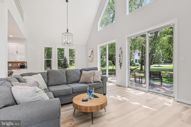 1012 Columbus Rd, Burlington, NJ 08016 - living area featuring high vaulted ceiling, a chandelier, light wood-style floors, and baseboards