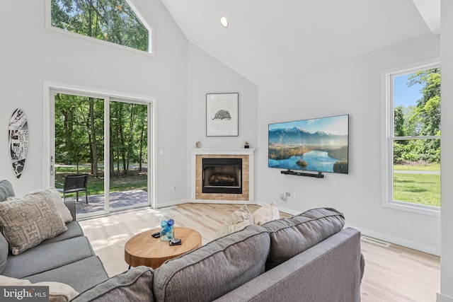 1012 Columbus Rd, Burlington, NJ 08016 - living room with high vaulted ceiling, wood finished floors, healthy amount of natural light, and a tiled fireplace