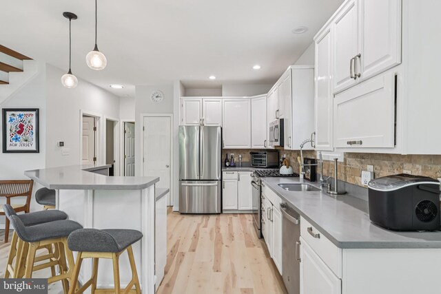 1012 Columbus Rd, Burlington, NJ 08016 - kitchen with appliances with stainless steel finishes, a kitchen bar, white cabinetry, light wood finished floors, and tasteful backsplash