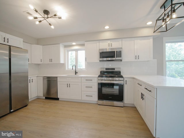 1200 First Ave, Media, PA 19063 - kitchen with appliances with stainless steel finishes, a peninsula, a chandelier, recessed lighting, and white cabinetry