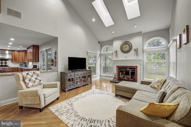 3 Monroe Ct, Plainsboro, NJ 08536 - living room with high vaulted ceiling, a fireplace, a skylight, light wood finished floors, and recessed lighting