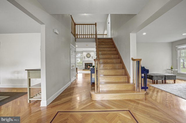3 Monroe Ct, Plainsboro, NJ 08536 - stairway with baseboards, a glass covered fireplace, and a towering ceiling