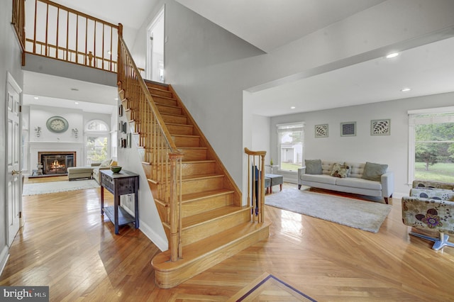 3 Monroe Ct, Plainsboro, NJ 08536 - stairway featuring a glass covered fireplace, plenty of natural light, recessed lighting, baseboards, and parquet flooring