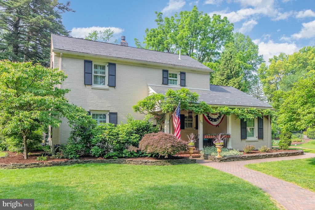 752 W S St, Carlisle, PA 17013 - view of front of house featuring covered porch, a front yard, brick siding, and a chimney