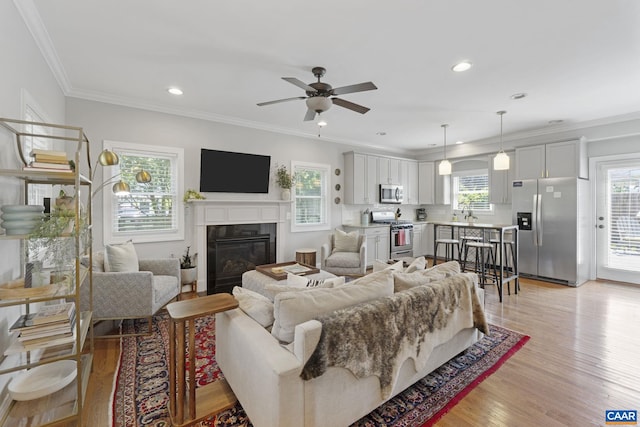 1012 Locust Ln, Charlottesville, VA 22901 - living room featuring a glass covered fireplace, ceiling fan, light wood-style flooring, crown molding, and recessed lighting