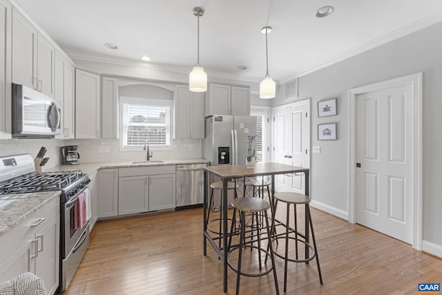 1012 Locust Ln, Charlottesville, VA 22901 - kitchen with stainless steel appliances, a sink, decorative backsplash, light wood finished floors, and ornamental molding