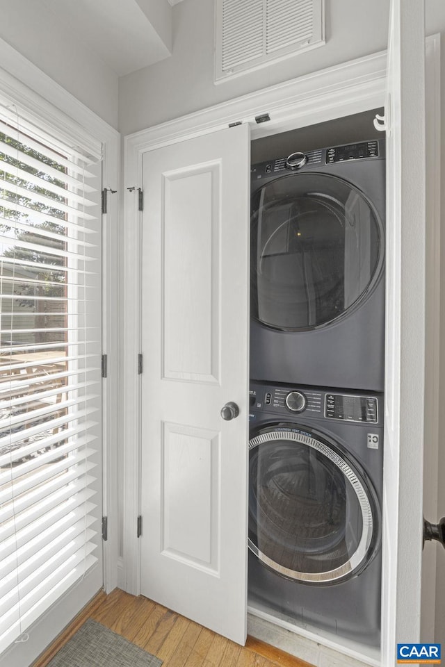 1012 Locust Ln, Charlottesville, VA 22901 - washroom featuring stacked washing machine and dryer and wood finished floors
