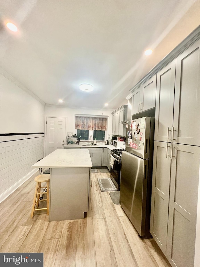 1719 S Chadwick St, Philadelphia, PA 19145 - kitchen with freestanding refrigerator, gas range oven, light wood finished floors, a center island, and recessed lighting