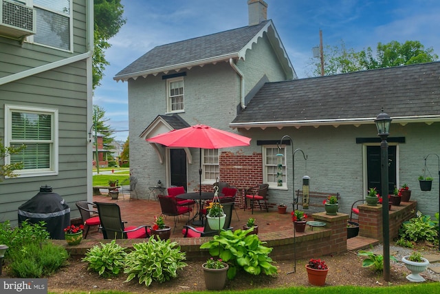 417 E Washington St, Charles Town, WV 25414 - rear view of house featuring a patio, a chimney, and brick siding