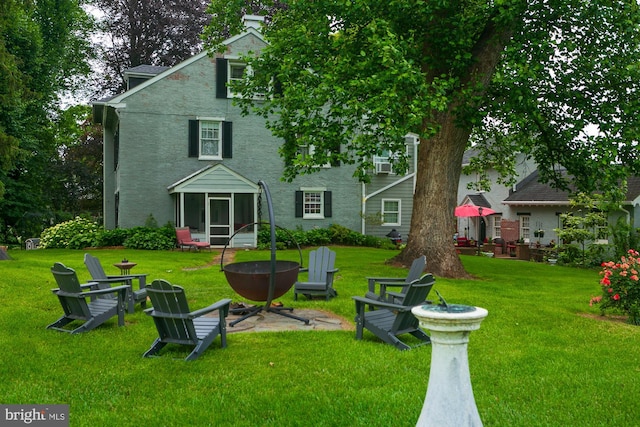 417 E Washington St, Charles Town, WV 25414 - rear view of property featuring a yard, a sunroom, a fire pit, and stucco siding