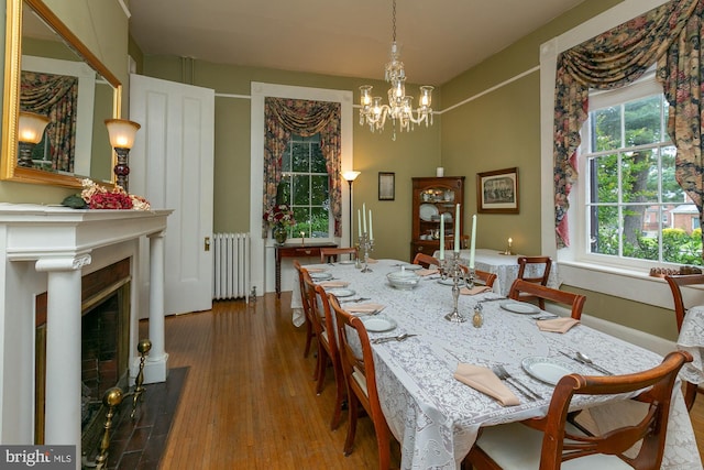 417 E Washington St, Charles Town, WV 25414 - dining room with radiator heating unit, a chandelier, wood finished floors, and a fireplace with flush hearth