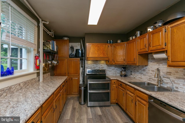 417 E Washington St, Charles Town, WV 25414 - kitchen with appliances with stainless steel finishes, light wood-style floors, brown cabinets, and tasteful backsplash