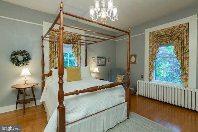 417 E Washington St, Charles Town, WV 25414 - bedroom featuring wood finished floors, radiator heating unit, and a chandelier