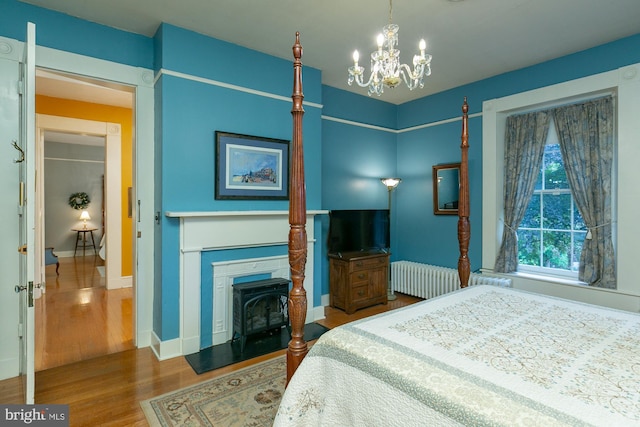417 E Washington St, Charles Town, WV 25414 - bedroom featuring wood finished floors, a chandelier, radiator heating unit, and a fireplace with flush hearth