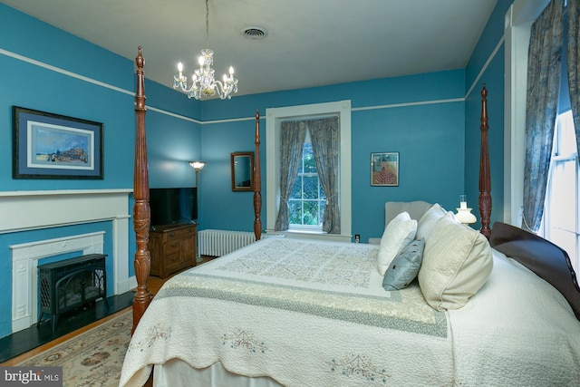 417 E Washington St, Charles Town, WV 25414 - bedroom with radiator heating unit, a chandelier, wood finished floors, and a fireplace