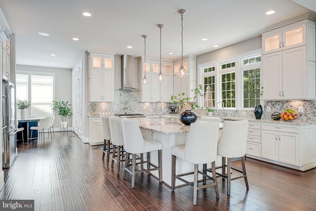 6513 Manor Ridge Ct, Falls Church, VA 22043 - kitchen featuring wall chimney range hood, stainless steel appliances, white cabinets, a breakfast bar area, and backsplash