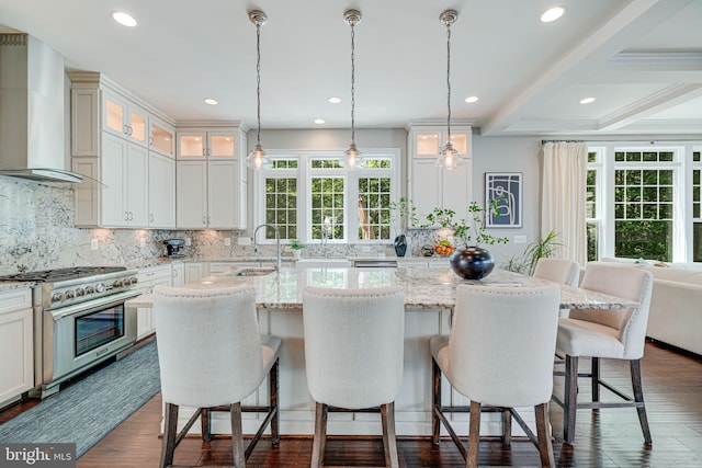 6513 Manor Ridge Ct, Falls Church, VA 22043 - kitchen with wall chimney range hood, stainless steel stove, a center island with sink, dark wood-style flooring, and recessed lighting