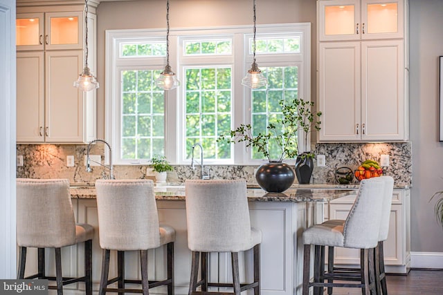 6513 Manor Ridge Ct, Falls Church, VA 22043 - kitchen featuring healthy amount of natural light, a kitchen bar, decorative backsplash, and light stone countertops
