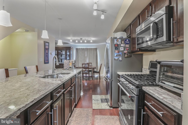 4613 Dillon St, Baltimore, MD 21224 - kitchen with stainless steel appliances, dark wood-style flooring, light stone counters, dark brown cabinetry, and decorative light fixtures