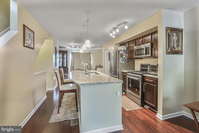 4613 Dillon St, Baltimore, MD 21224 - kitchen featuring appliances with stainless steel finishes, dark wood-style floors, an island with sink, and dark brown cabinets