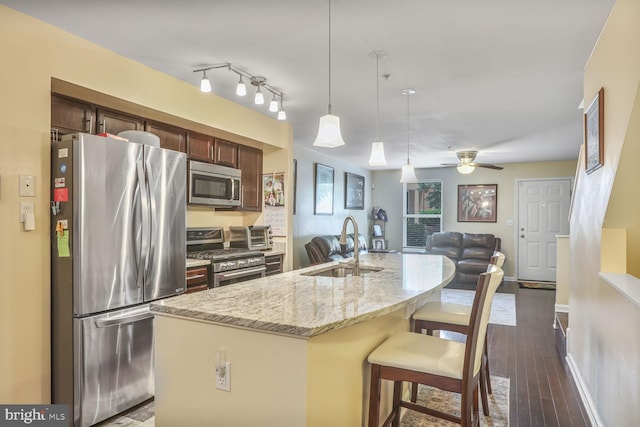 4613 Dillon St, Baltimore, MD 21224 - kitchen with stainless steel appliances, dark wood-style flooring, open floor plan, a ceiling fan, and hanging light fixtures