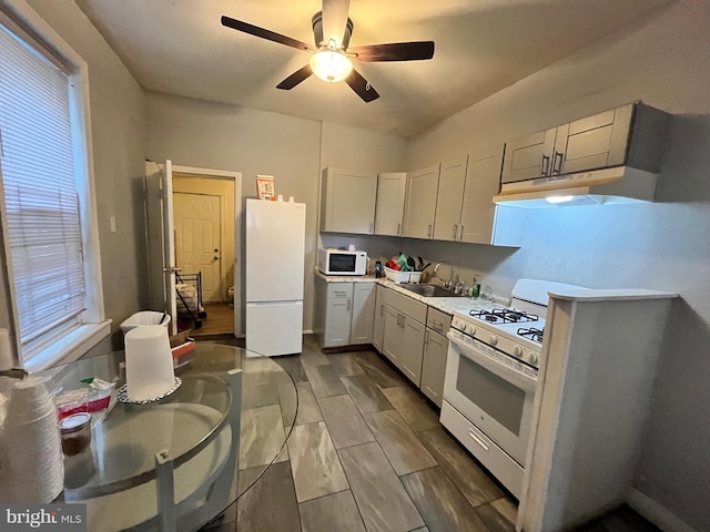 5131 Ludlow St, Philadelphia, PA 19139 - kitchen featuring white appliances, ceiling fan, a sink, light countertops, and under cabinet range hood