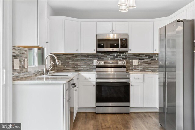 11239 Putman Rd, Thurmont, MD 21788 - kitchen featuring appliances with stainless steel finishes, a sink, white cabinetry, decorative backsplash, and wood finished floors
