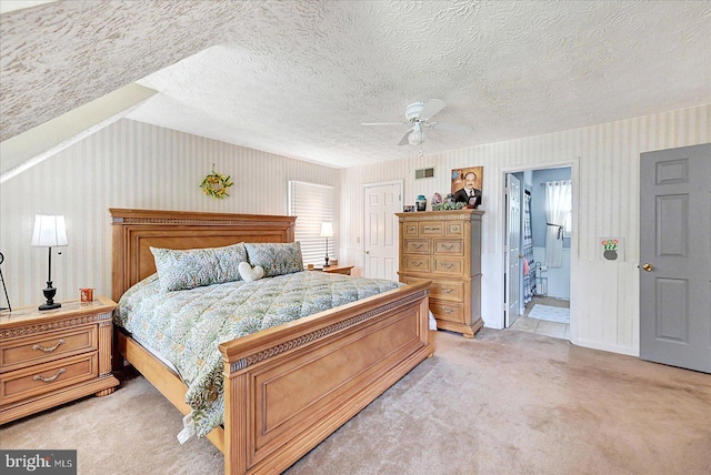 11 Thomas Cir, New Freedom, PA 17349 - bedroom with light colored carpet, wallpapered walls, vaulted ceiling, a ceiling fan, and connected bathroom