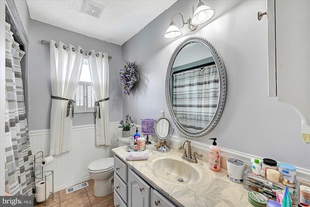 11 Thomas Cir, New Freedom, PA 17349 - full bathroom featuring vanity, a wainscoted wall, a textured ceiling, and tile patterned floors