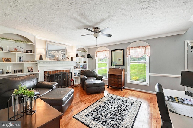 11 Thomas Cir, New Freedom, PA 17349 - living area featuring a ceiling fan, wood finished floors, a brick fireplace, ornamental molding, and a textured ceiling