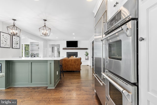 661 Timber Ln, Devon, PA 19333 - kitchen featuring green cabinetry, light countertops, a chandelier, stainless steel double oven, and a brick fireplace