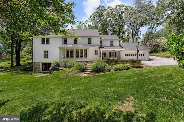 661 Timber Ln, Devon, PA 19333 - rear view of property with concrete driveway, a lawn, a garage, and a shingled roof