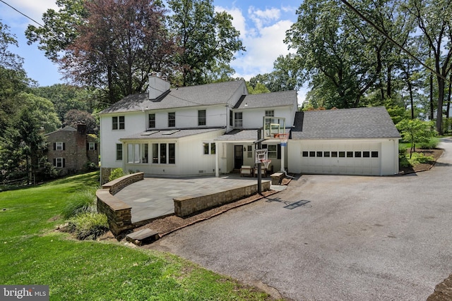 661 Timber Ln, Devon, PA 19333 - back of house with roof with shingles, a yard, asphalt driveway, a chimney, and an attached garage