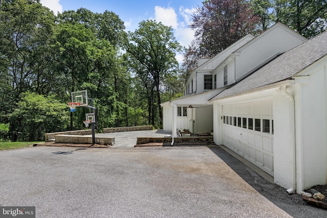 661 Timber Ln, Devon, PA 19333 - view of side of property featuring driveway, a shingled roof, an attached garage, and board and batten siding