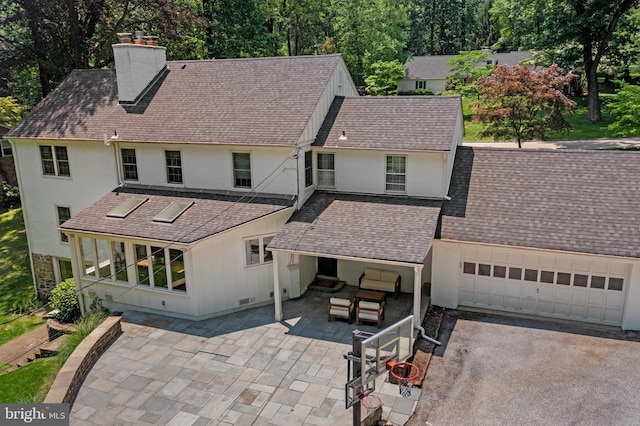 661 Timber Ln, Devon, PA 19333 - back of house with a chimney, asphalt driveway, a shingled roof, a garage, and stucco siding
