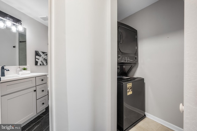 2701 Bellforest Ct Unit 305, Vienna, VA 22180 - laundry room featuring stacked washing machine and dryer and baseboards