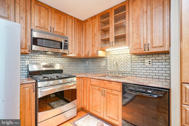 1035 S Beecham Rd, Williamstown, NJ 08094 - kitchen with appliances with stainless steel finishes, a sink, light stone countertops, glass insert cabinets, and decorative backsplash