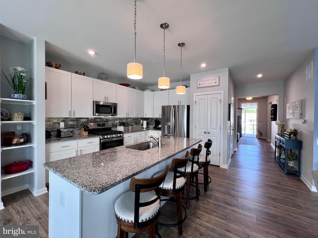 1143 Kayla Ln, Townsend, DE 19734 - kitchen featuring appliances with stainless steel finishes, a sink, dark wood finished floors, white cabinetry, and a breakfast bar