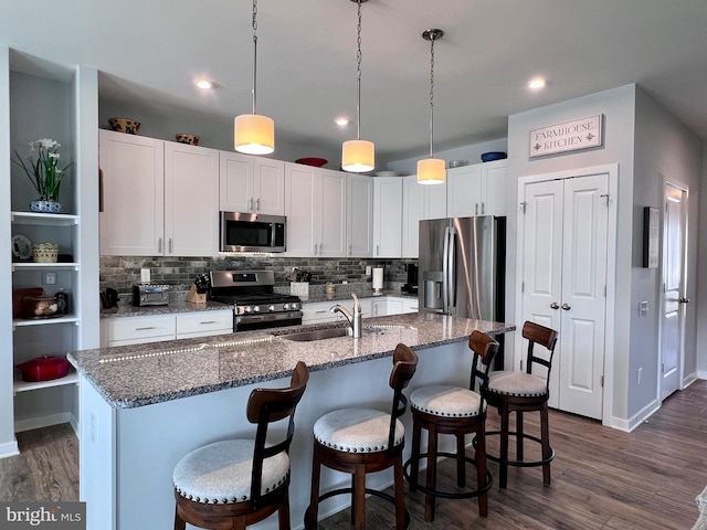 1143 Kayla Ln, Townsend, DE 19734 - kitchen featuring stainless steel appliances, a sink, dark wood finished floors, tasteful backsplash, and white cabinets
