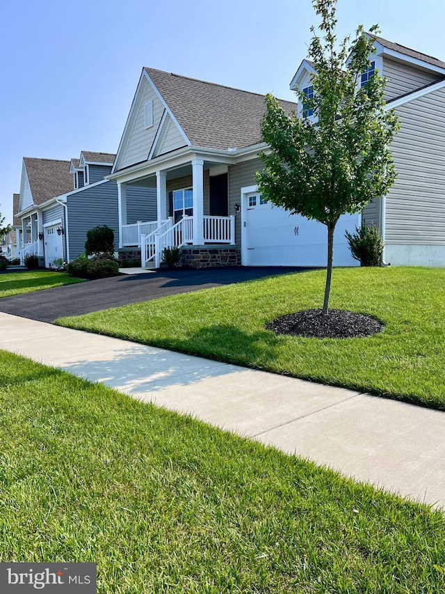 1143 Kayla Ln, Townsend, DE 19734 - view of front of property with asphalt driveway, covered porch, a front lawn, and a garage