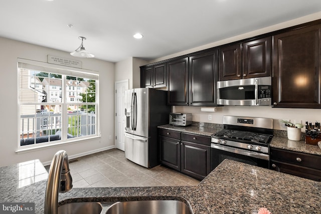 45711 Winding Branch Ter, Sterling, VA 20166 - kitchen featuring stainless steel appliances, baseboards, dark stone countertops, light tile patterned floors, and a sink