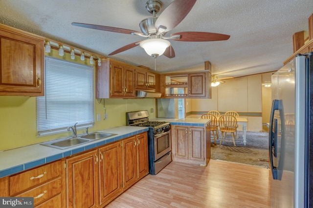 32588 Captains Way, Millsboro, DE 19966 - kitchen with appliances with stainless steel finishes, a sink, a textured ceiling, light wood-type flooring, and tile countertops