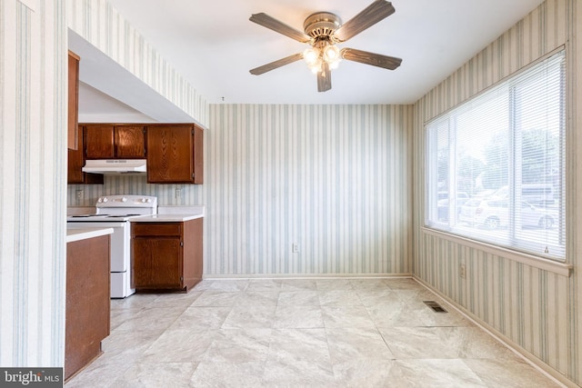 8798 Victory Ct, Walkersville, MD 21793 - kitchen with under cabinet range hood, wallpapered walls, white electric range oven, light countertops, and a ceiling fan