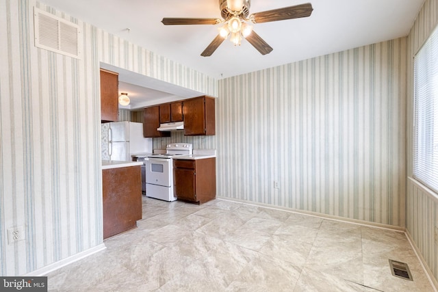 8798 Victory Ct, Walkersville, MD 21793 - kitchen with white appliances, under cabinet range hood, light countertops, wallpapered walls, and ceiling fan
