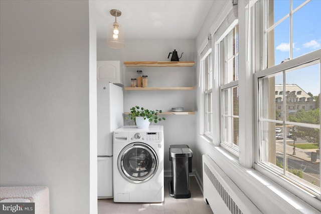 3028 Wisconsin Ave NW Unit 402, Washington, DC 20016 - laundry room featuring washer / clothes dryer, radiator, healthy amount of natural light, and light tile patterned floors